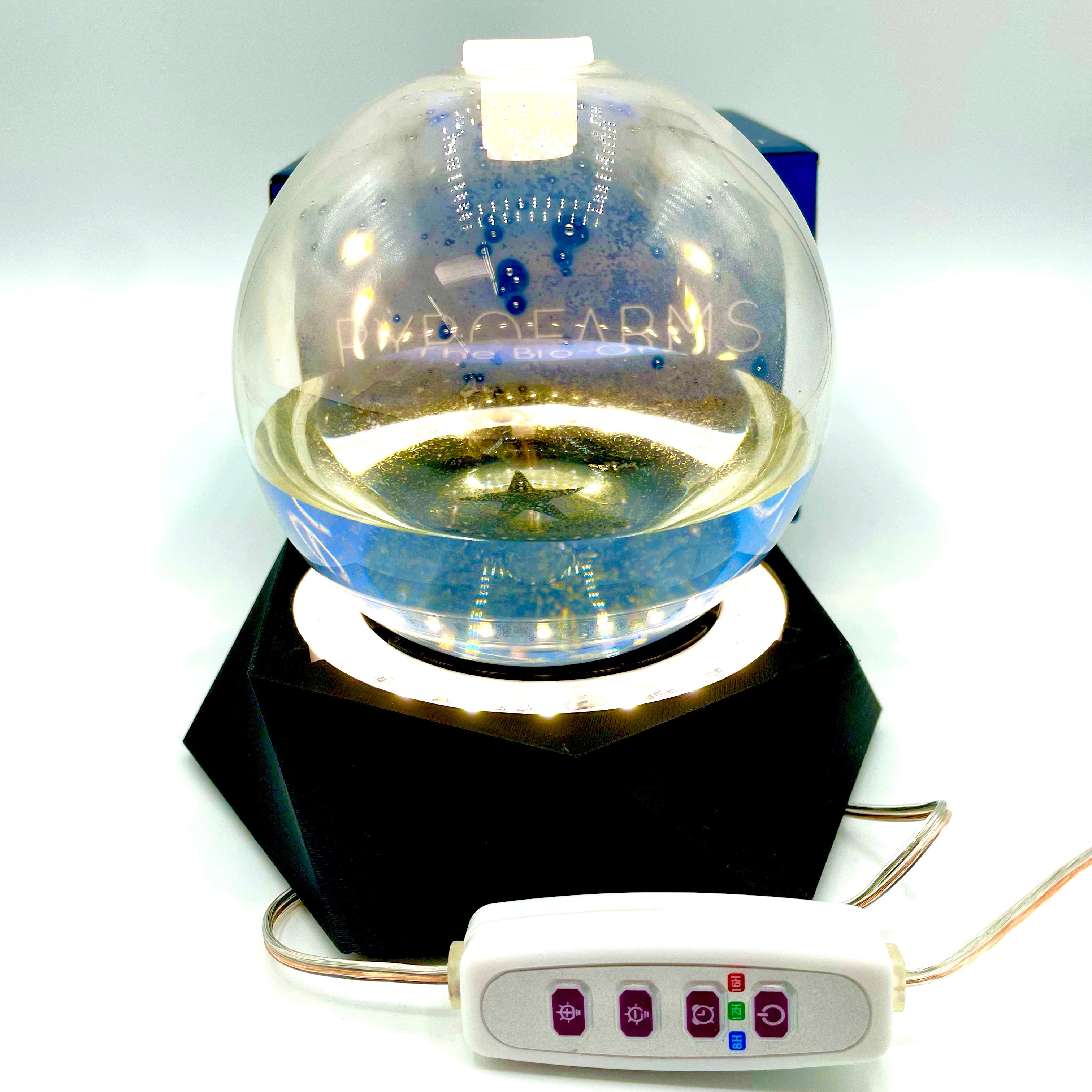 PyroDino LED grow light illuminating a Bioluminescent Bio-Orb on a custom black resin stand.