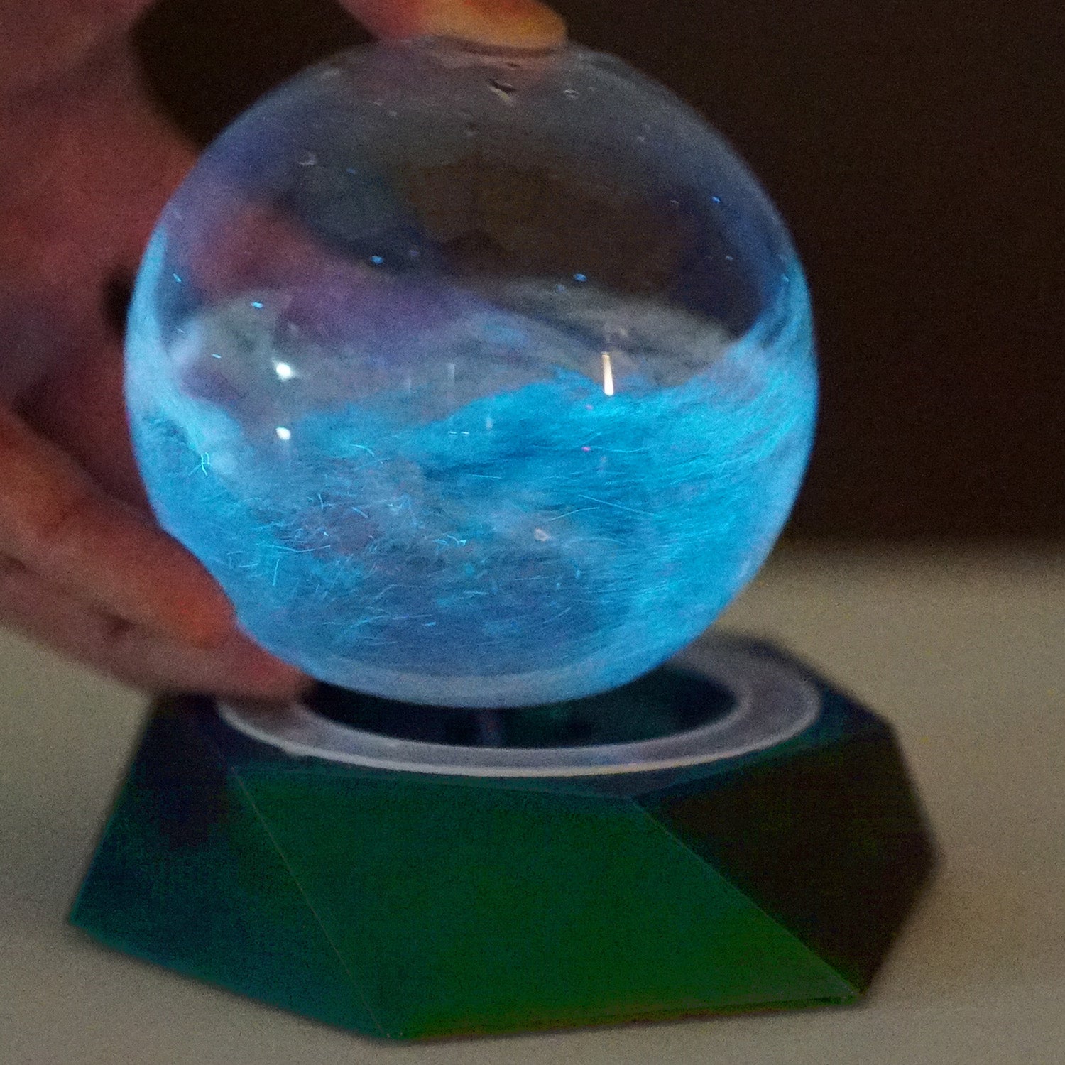 Glowing PyroDino Bio-Orb on the programmable LED grow light in a dark room setup